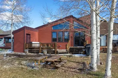 a red house with a picnic table in front of it at 701B Quail in Fraser