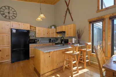 a kitchen with a black refrigerator and wooden cabinets at 701B Quail in Fraser