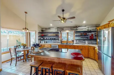 a kitchen with a refrigerator and a table and chairs at Work and Play! Spacious Lake-View Home in Greeley in Greeley