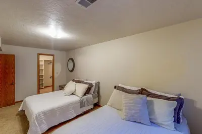 a bedroom with two beds and a mirror at Work and Play! Spacious Lake-View Home in Greeley in Greeley