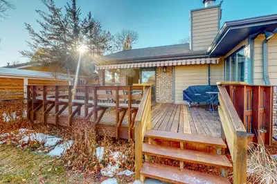 a large wooden deck in front of a house at Work and Play! Spacious Lake-View Home in Greeley in Greeley