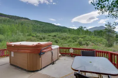 a hot tub and a table on a deck with a view at 1 Mi to Keystone Lifts Hot Tub Haven with Mtn Views in Keystone