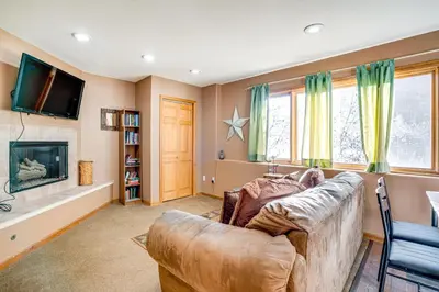 a living room with a couch and a television at 1 Mi to Keystone Lifts Hot Tub Haven with Mtn Views in Keystone