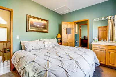 a bedroom with a large bed and a bathroom at 1 Mi to Keystone Lifts Hot Tub Haven with Mtn Views in Keystone
