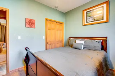 a bedroom with a bed with a wooden frame and a door at 1 Mi to Keystone Lifts Hot Tub Haven with Mtn Views in Keystone