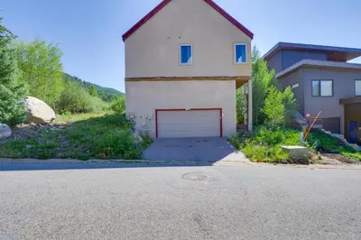 a white garage with a red door on the side of a house at 1 Mi to Keystone Lifts Hot Tub Haven with Mtn Views in Keystone