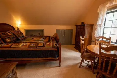 a bedroom with a bed and a table and chairs at Warm Woodland Getaway with Land in Red Feather Lakes