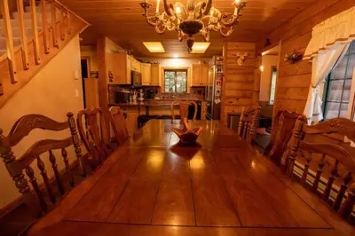 a dining room table with chairs and a chandelier at Warm Woodland Getaway with Land in Red Feather Lakes