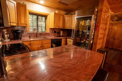 a large wooden kitchen with a wooden table in it at Warm Woodland Getaway with Land in Red Feather Lakes