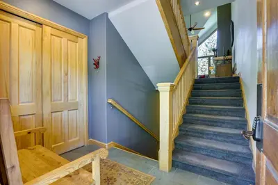 a staircase with blue walls and a wooden door at Walk to Ski Lifts Townhome with Hot Tub in Keystone in Keystone