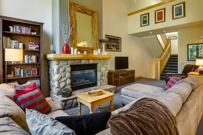a living room with a couch and a fireplace at Walk to Ski Lifts Townhome with Hot Tub in Keystone in Keystone