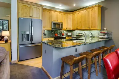 a kitchen with a large counter with a refrigerator at Walk to Ski Lifts Townhome with Hot Tub in Keystone in Keystone