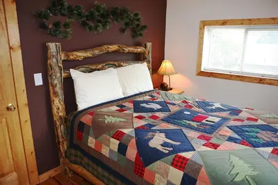 a bedroom with a bed with a quilt on it at Lazy R Cottages- 4 cabin in Estes Park