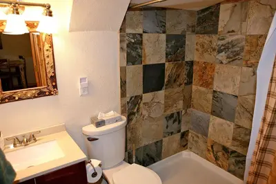 a bathroom with a toilet and a sink and a tub at Lazy R Cottages- 4 cabin in Estes Park