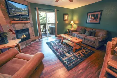 a living room with leather furniture and a fireplace at Fawn Valley Inn- 297 condo in Estes Park