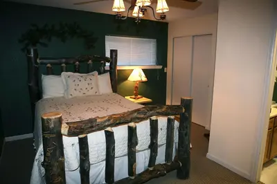a bedroom with a wooden bed in a room at Fawn Valley Inn- 297 condo in Estes Park