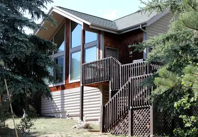 a house with a wooden staircase in front of it at Sunnyside Knoll- 18 cabin in Estes Park
