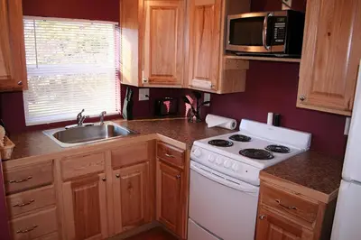 a small kitchen with a stove and a sink at Triple R Cottages- 6 cabin in Estes Park