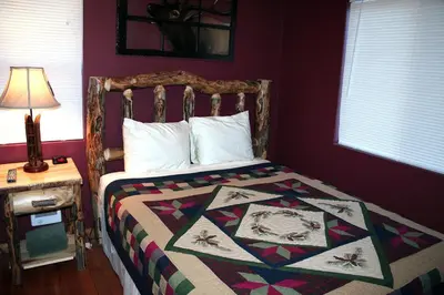 a bedroom with a bed with a quilt on it at Triple R Cottages- 6 cabin in Estes Park
