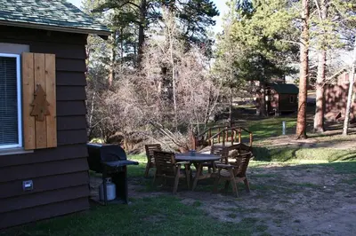 a table and chairs in a yard next to a house at Triple R Cottages- 6 cabin in Estes Park