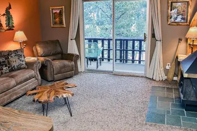 a living room with a couch and chair and a large window at Fawn Valley Inn- 284 condo in Estes Park