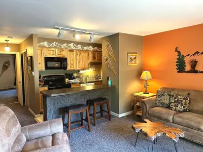 a living room with a couch and a kitchen at Fawn Valley Inn- 284 condo in Estes Park