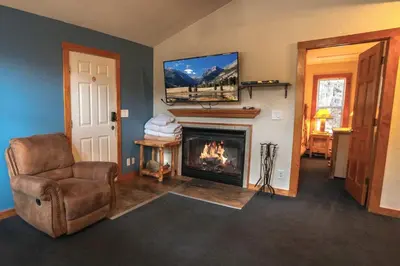 a living room with a chair and a fireplace at Timber Creek Chalets- 9 chalet in Estes Park