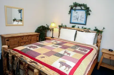 a bedroom with a bed with a quilt on it at Timber Creek Chalets- 9 chalet in Estes Park