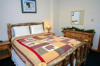 a bedroom with a bed with a quilt on it at Timber Creek Chalets- 9 chalet in Estes Park