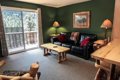 a living room with a couch and a table at Fawn Valley Inn- 280 condo in Estes Park