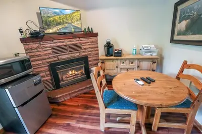a dining room with a table and a fireplace at Sunnyside Knoll- 10 studio in Estes Park