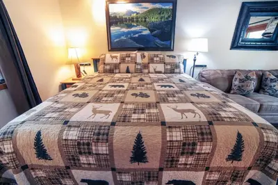 a bedroom with a bed with a quilt on it at Sunnyside Knoll- 10 studio in Estes Park