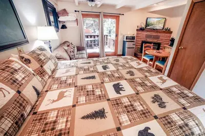 a bedroom with a bed with a quilt on it at Sunnyside Knoll- 10 studio in Estes Park