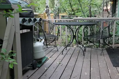 a patio with a table and chairs on a deck at Sunnyside Knoll- 10 studio in Estes Park