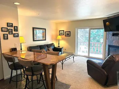 a living room with a table and a couch at Fawn Valley Inn- 292 apts in Estes Park