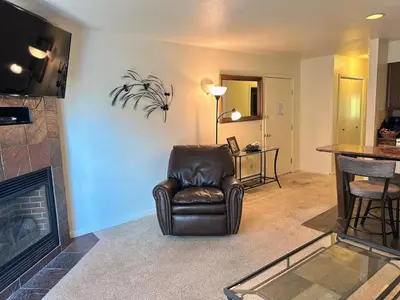 a living room with a chair and a fireplace at Fawn Valley Inn- 292 apts in Estes Park