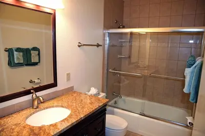a bathroom with a sink and a shower with a glass door at Fawn Valley Inn- 292 apts in Estes Park