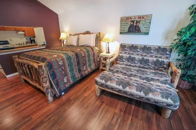 a bedroom with a bed and a couch at Fawn Valley Inn- 295 condo in Estes Park