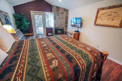 a bedroom with a bed with a colorful blanket at Fawn Valley Inn- 295 condo in Estes Park
