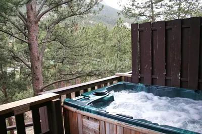 a hot tub on a deck with snow at Fawn Valley Inn- 295 condo in Estes Park