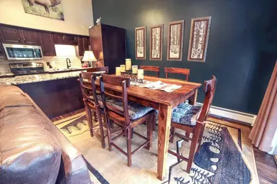 a dining room with a wooden table and chairs at Fawn Valley Inn- 210 condo in Estes Park