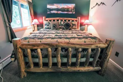 a bedroom with a bed made out of logs at Fawn Valley Inn- 210 condo in Estes Park