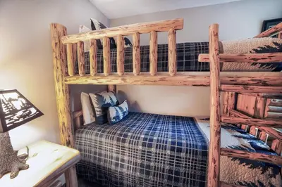 a bedroom with two bunk beds and a desk at Fawn Valley Inn- 210 condo in Estes Park