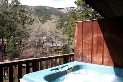 a hot tub on a balcony with a view of a mountain at Fawn Valley Inn- 255 condo in Estes Park