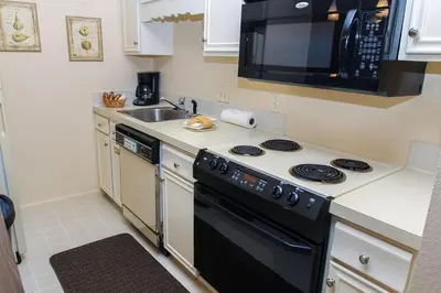 a kitchen with a stove and a sink and a microwave at Fawn Valley Inn- 278 condo in Estes Park