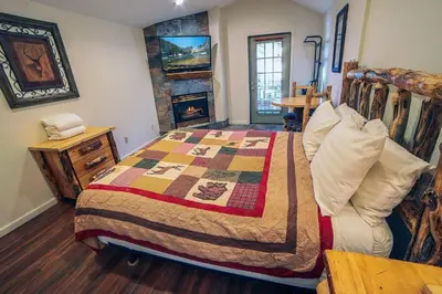 a bedroom with a bed and a fireplace at Fawn Valley Inn- 296 apts in Estes Park