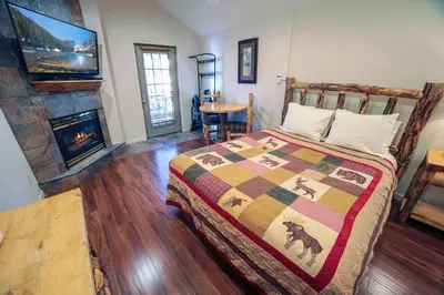 a bedroom with a bed and a fireplace at Fawn Valley Inn- 296 apts in Estes Park