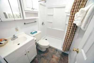 a white bathroom with a toilet and a sink at Fawn Valley Inn- 296 apts in Estes Park
