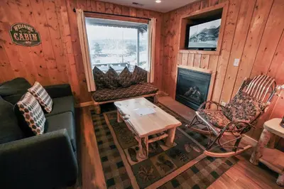 a living room with a couch and chairs and a fireplace at Lazy R Cottages- 8 cabin in Estes Park
