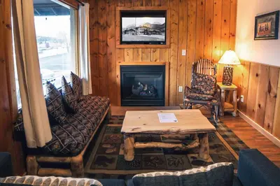 a living room with a table and a fireplace at Lazy R Cottages- 8 cabin in Estes Park